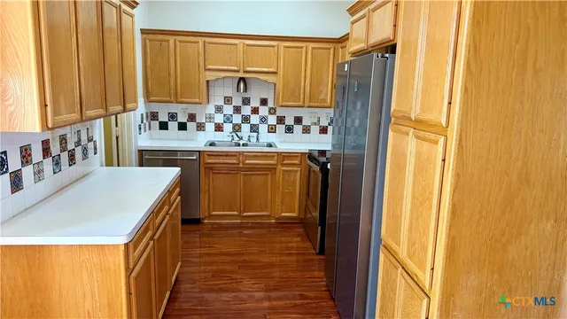 a kitchen with stainless steel appliances granite countertop a refrigerator and a stove