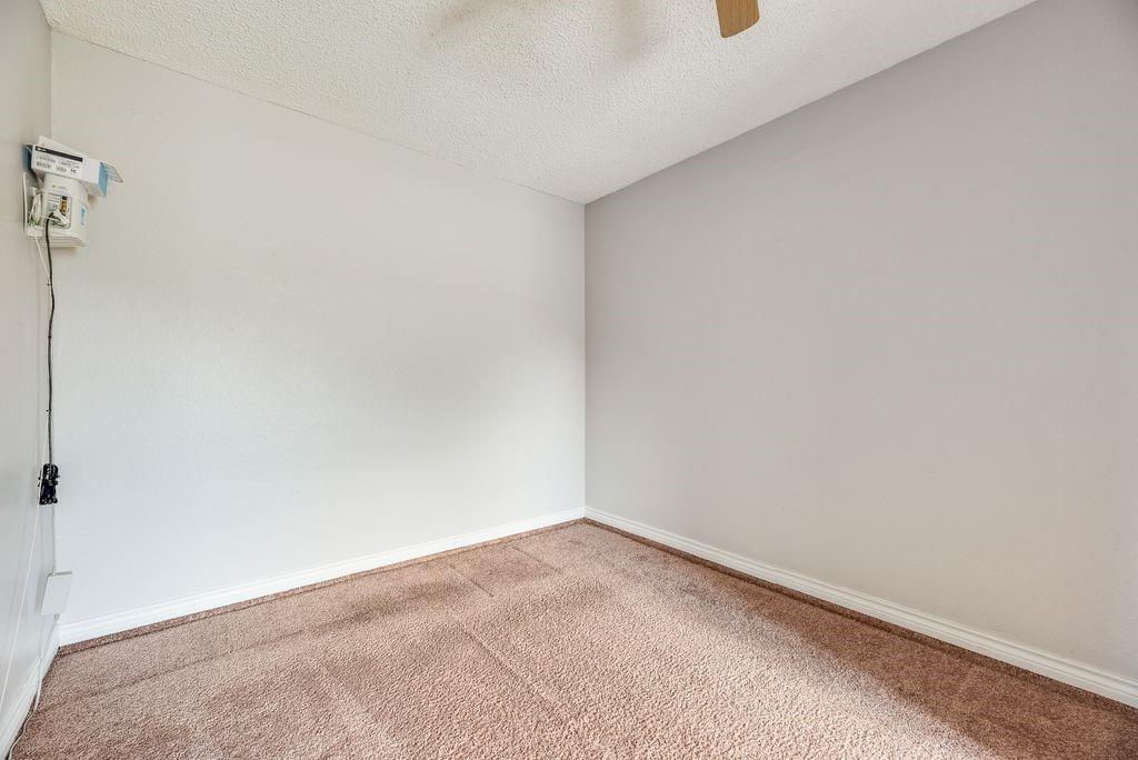 5610 Eagle Rock Road Arlington, TX 76017 - Photo 27 of 33 Neutral-toned walls complement the textured carpet flooring