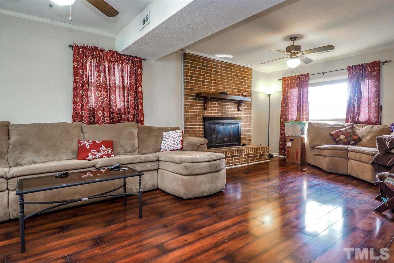 3953 Haithcock Road Raleigh, NC 27604 - Photo 15 of 25 a living room with furniture and a fireplace