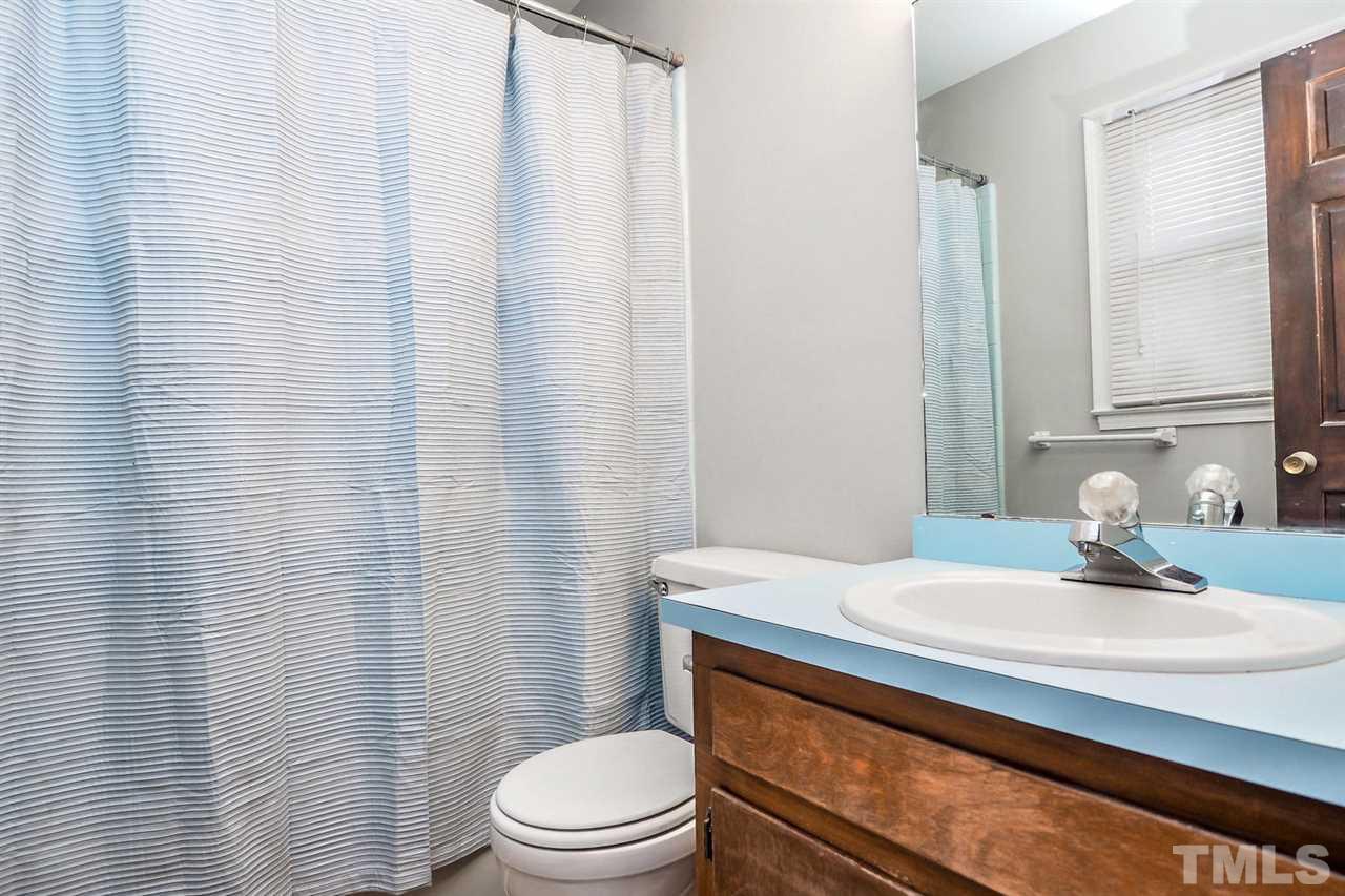 3953 Haithcock Road Raleigh, NC 27604 - Photo 9 of 25 a bathroom with a sink a toilet and shower curtain