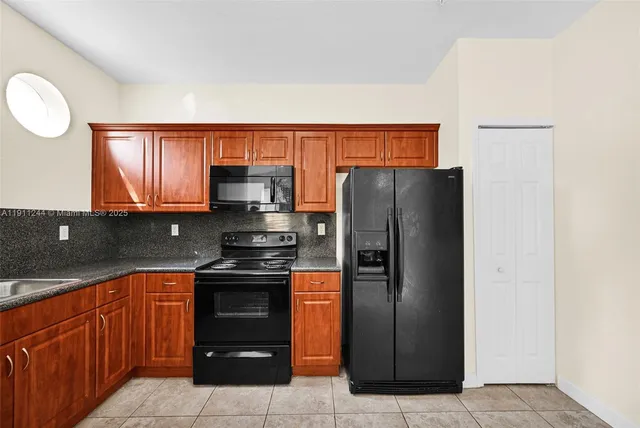 a kitchen with stainless steel appliances granite countertop a refrigerator and a stove top oven