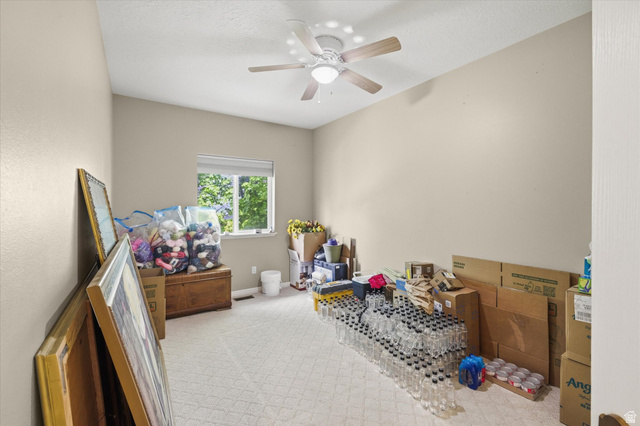 560 East 700 North Logan, UT 84321 - Photo 13 of 32 Carpeted room featuring a ceiling fan, a window with exterior tree views, and light-colored walls