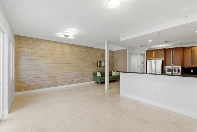 a kitchen with stainless steel appliances granite countertop a stove a sink and a refrigerator with wooden cabinets