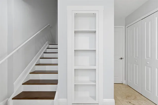 a view of a hallway and a livingroom with furniture and windows