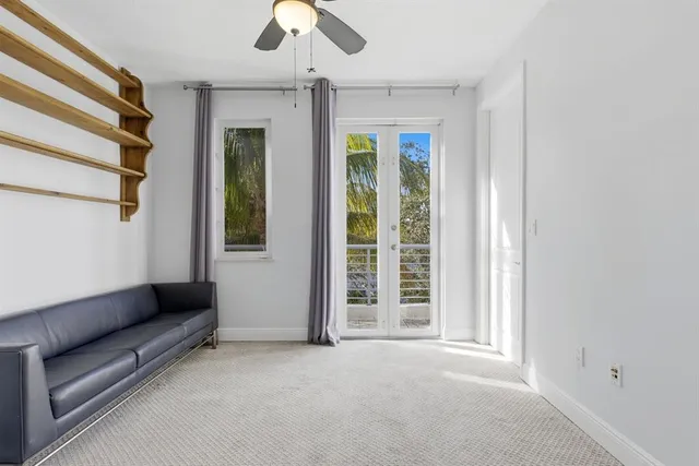 a view of a livingroom with wooden floor and a ceiling fan