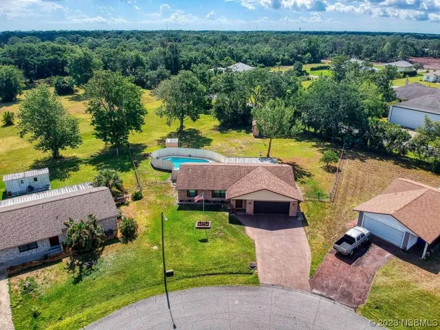 an aerial view of a house with yard swimming pool and outdoor seating