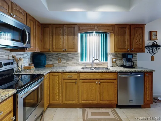 a kitchen with stainless steel appliances granite countertop a sink stove and microwave