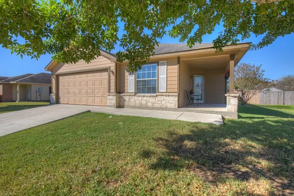 a front view of a house with a garden and yard