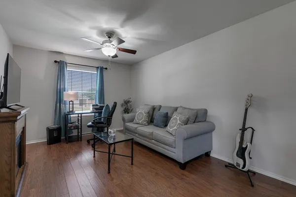 a living room with furniture a ceiling fan and a wooden floor