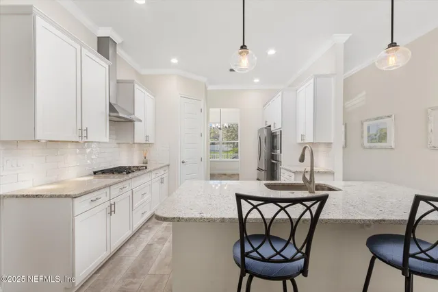 a kitchen with stainless steel appliances granite countertop a stove a sink and a refrigerator
