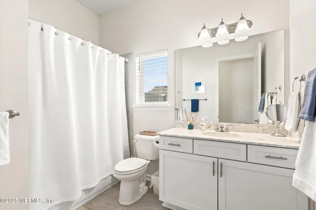 a bathroom with a double vanity sink mirror and toilet