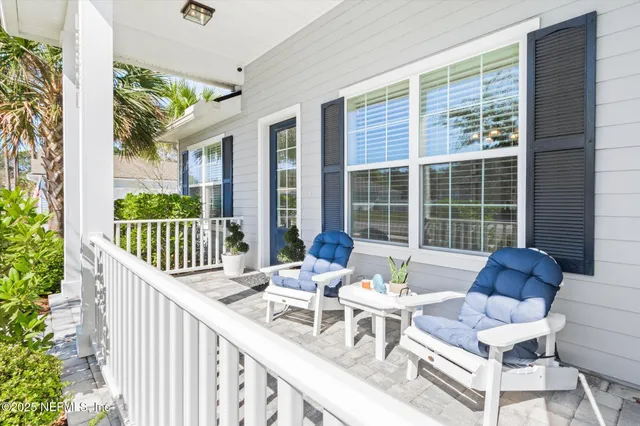 a view of a patio with a dining table and chairs with wooden floor