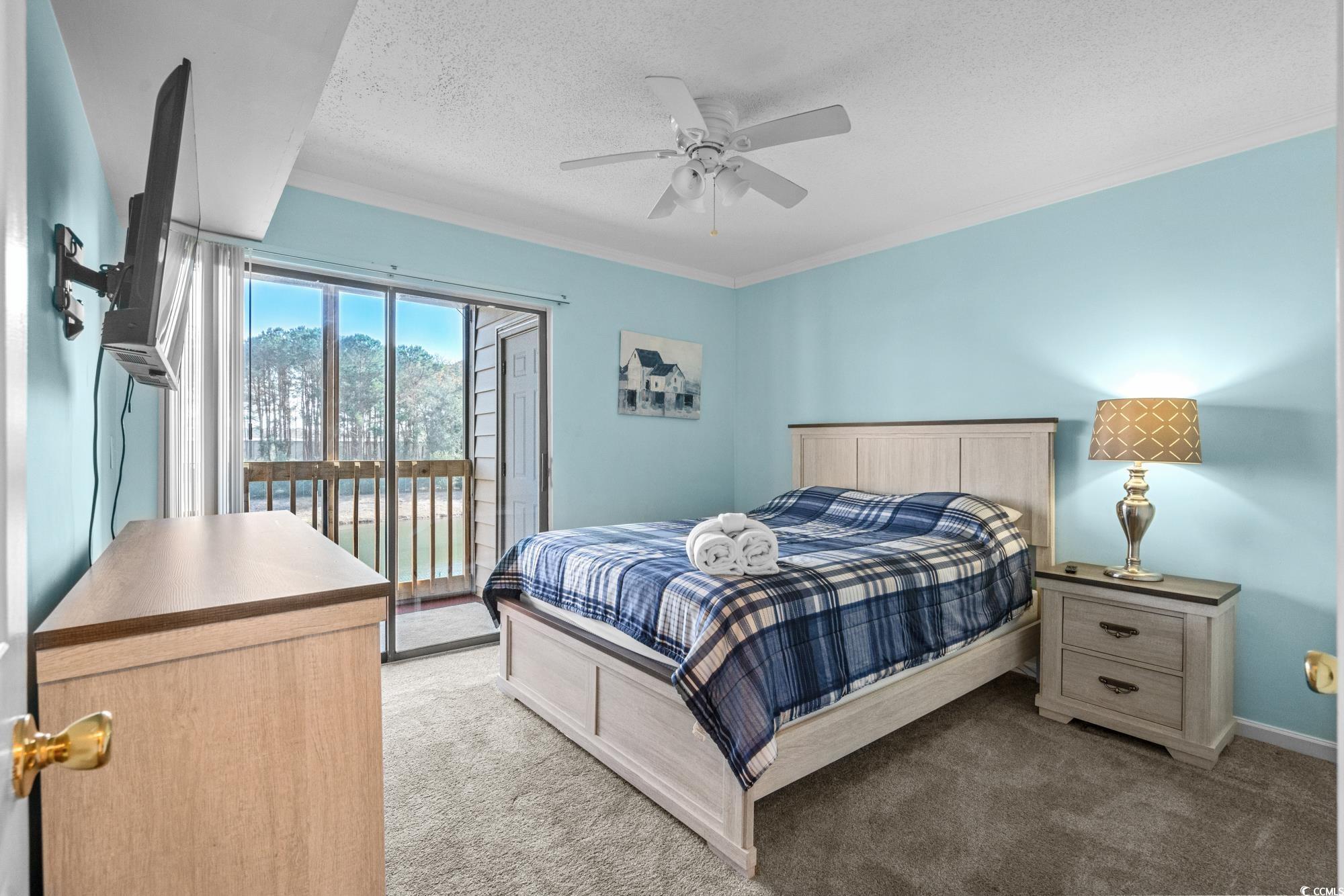 1356 Glenns Bay Road, Unit 203D Surfside Beach, SC 29575 - Photo 14 of 38 Bedroom featuring light carpet, access to exterior, a textured ceiling, ornamental molding, and a ceiling fan