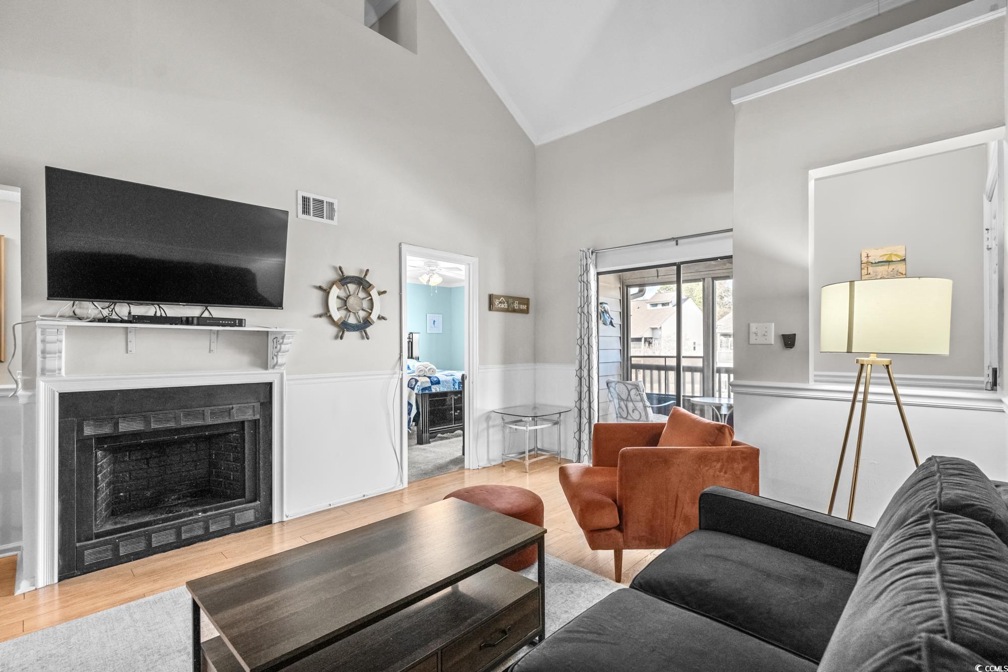 1356 Glenns Bay Road, Unit 203D Surfside Beach, SC 29575 - Photo 5 of 38 Living area featuring wood finished floors, high vaulted ceiling, and a fireplace