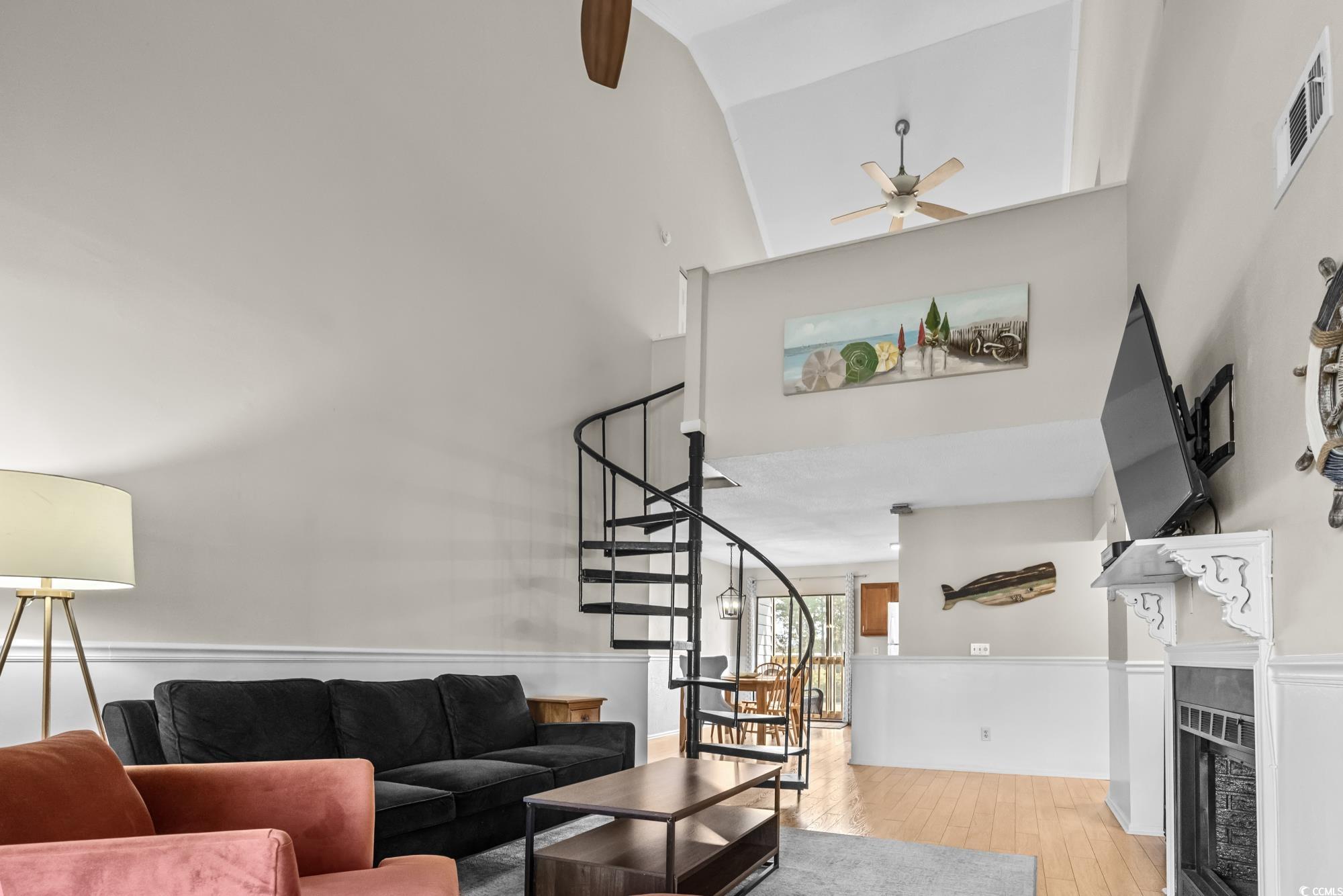 1356 Glenns Bay Road, Unit 203D Surfside Beach, SC 29575 - Photo 7 of 38 Living area featuring light wood-style floors, a tile fireplace, a high ceiling, stairway, and ceiling fan