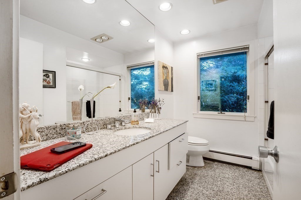 33 Sky View Circle Newton, MA 02459 - Photo 13 of 42 a bathroom with a granite countertop sink a large mirror and a shower