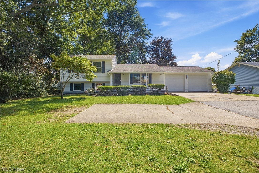 4845 New Road Austintown, OH 44515 - Photo 34 of 40 Split-level residence featuring a white exterior, dark window shutters, and a front lawn with mature trees