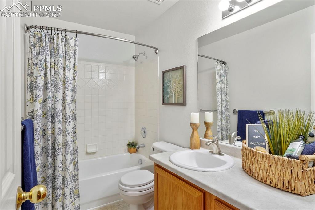 4748 Brant Road Colorado Springs, CO 80911 - Photo 14 of 19 a bathroom with a granite countertop toilet a sink and a bathtub