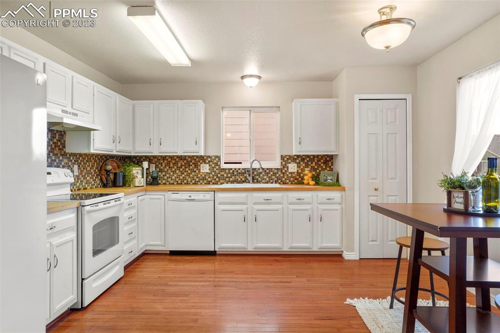 4748 Brant Road Colorado Springs, CO 80911 - Photo 4 of 19 a kitchen with granite countertop white cabinets and white appliances