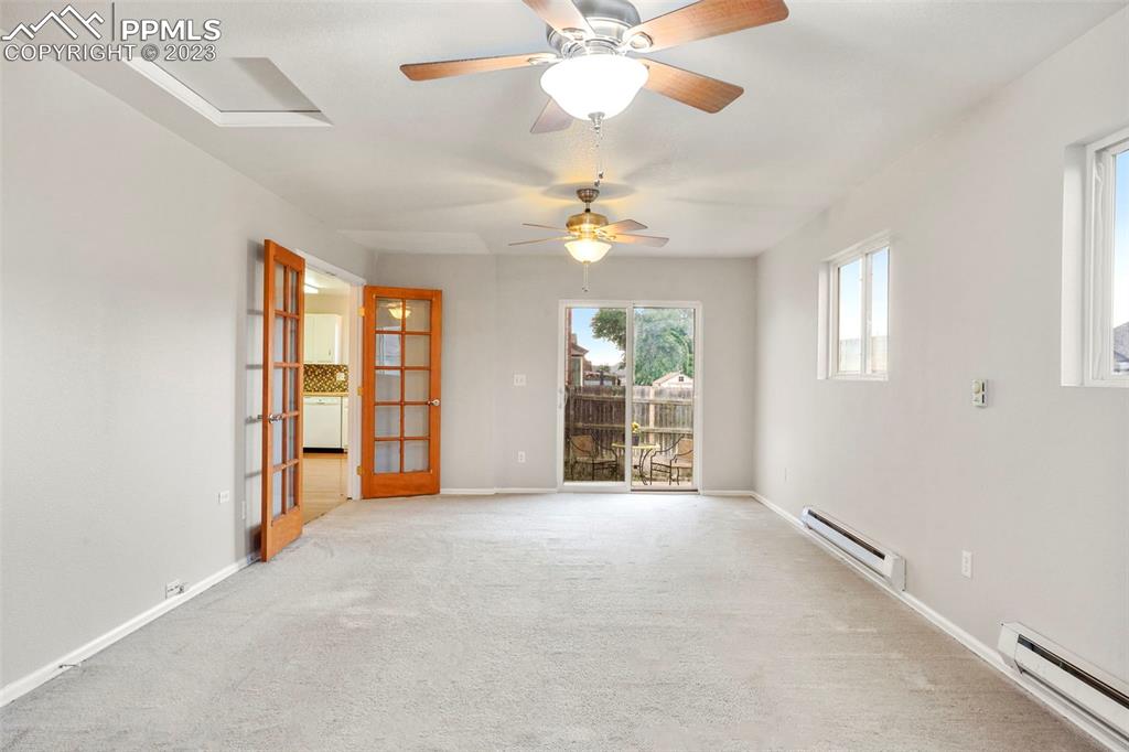 4748 Brant Road Colorado Springs, CO 80911 - Photo 8 of 19 an empty room with chandelier fan and windows