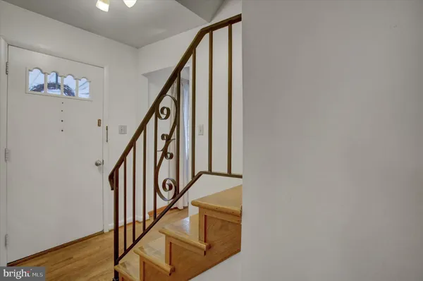 a view of staircase with lots of frames on wall and wooden floor