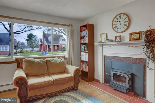 a living room with furniture a fireplace and a large window