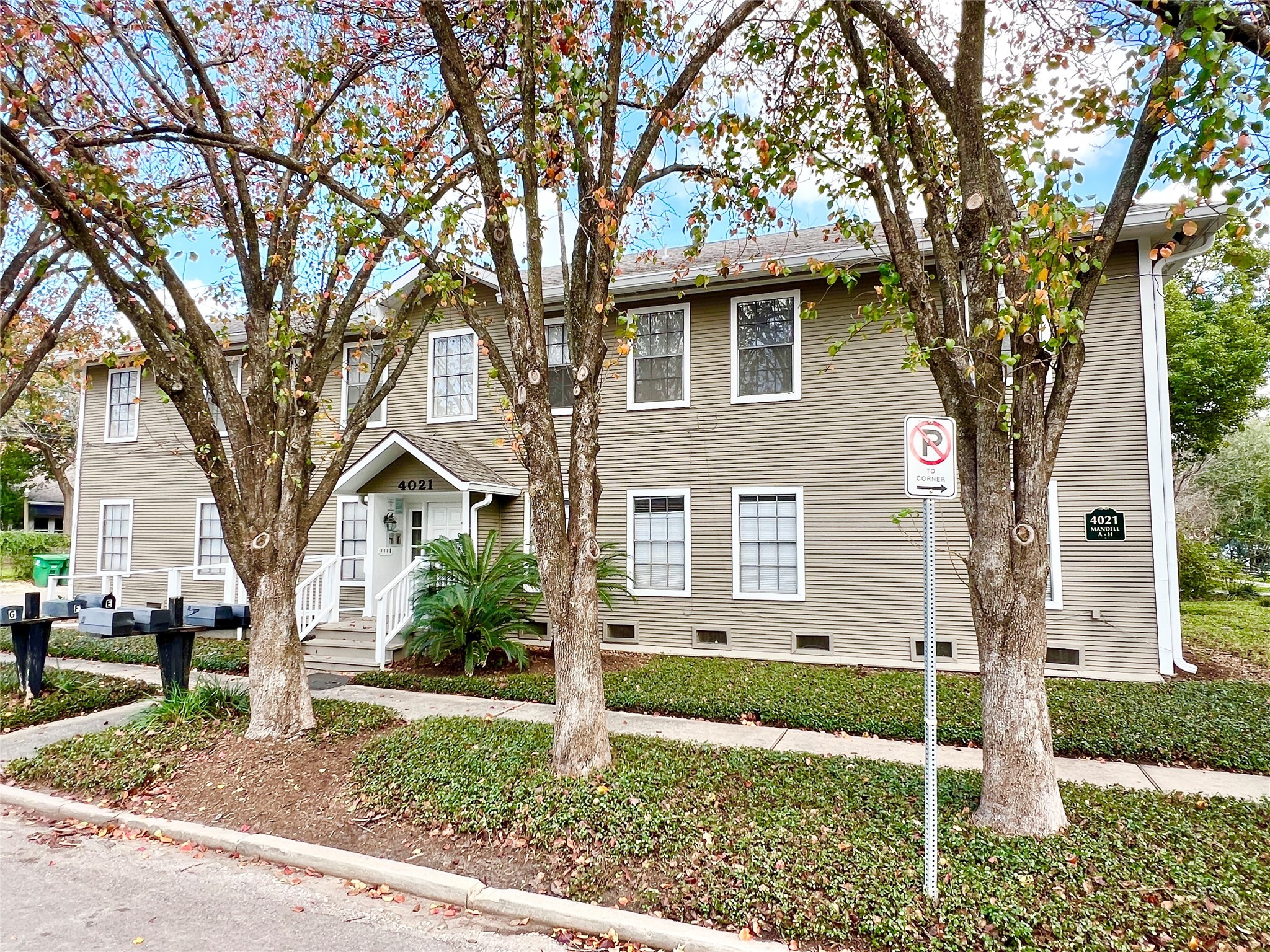 a front view of a house with a yard and large trees