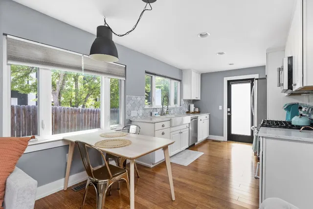 a dining room with furniture a chandelier and wooden floor