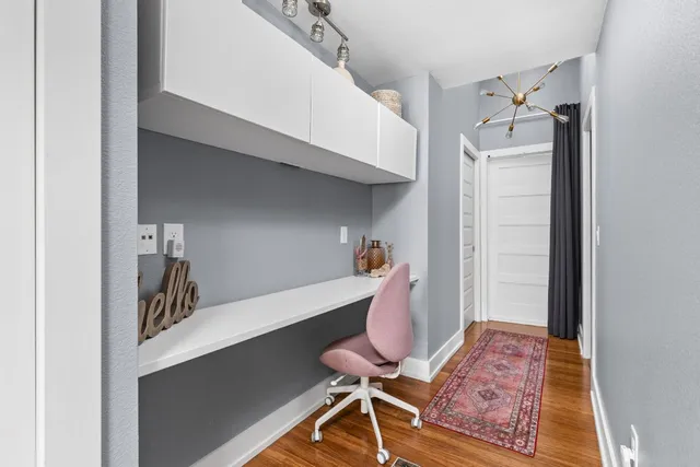 a view of a hallway with workspace and wooden floor