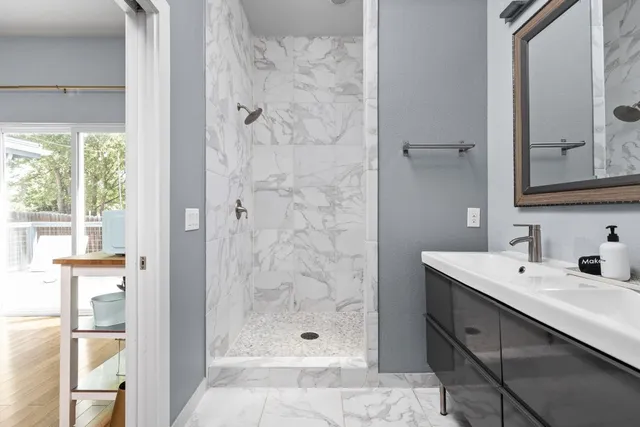 a bathroom with a shower sink and mirror