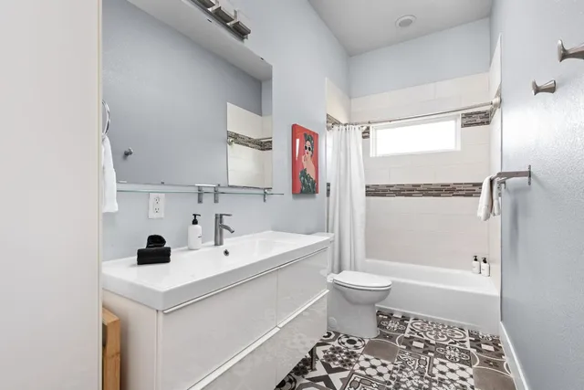 a bathroom with a sink a toilet and shower