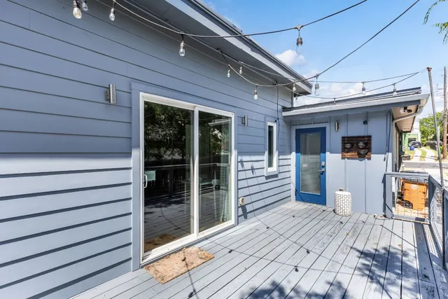 a balcony with wooden floor and outdoor seating
