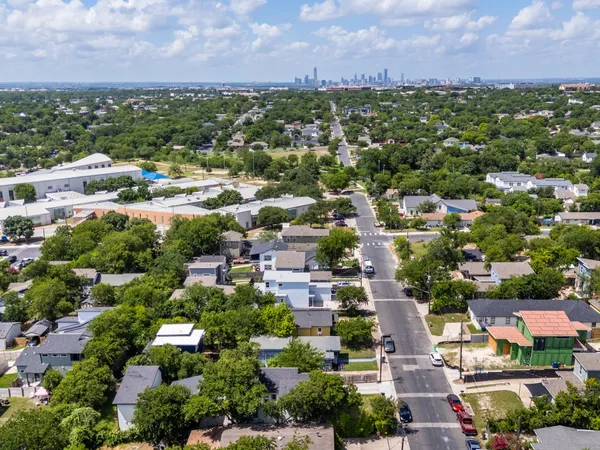 an aerial view of residential houses with outdoor space and a building