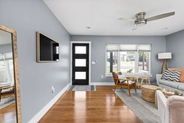 a living room with furniture and a wooden floor