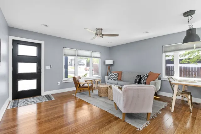 a living room with furniture wooden floor and windows