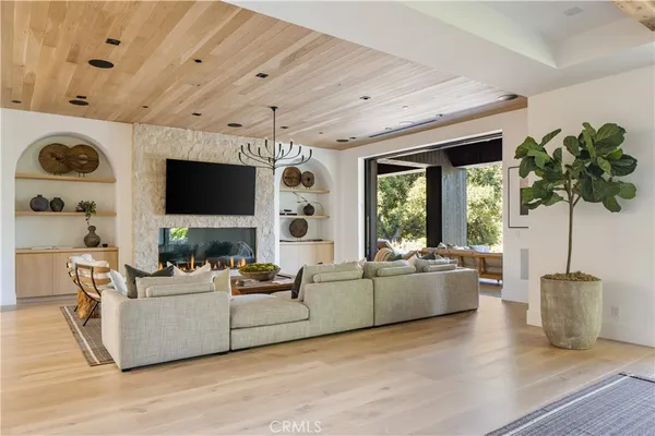 a living room with furniture a flat screen tv and a large window
