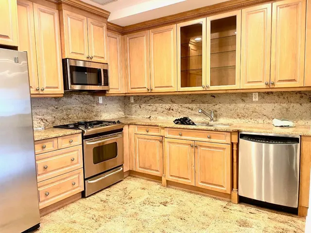 a kitchen with granite countertop a stove a sink and a microwave