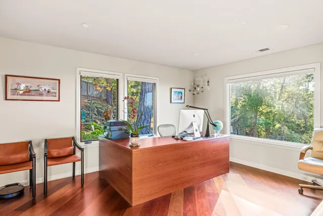 a living room with furniture a large window and wooden floor