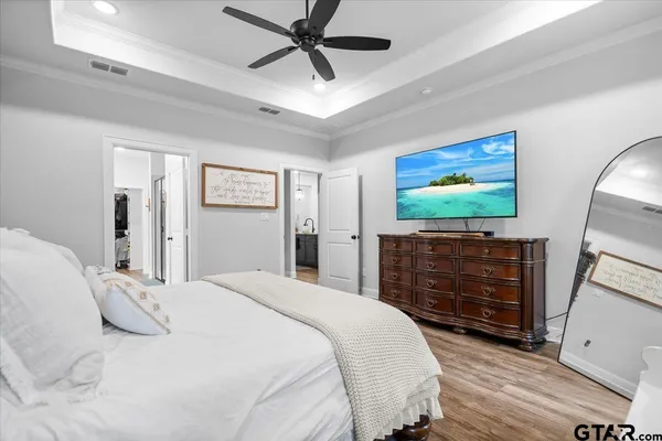 a spacious bedroom with a bed and a flat screen tv