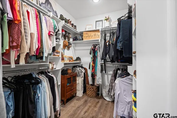 a view of walk in closet with clothes