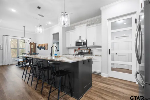 a kitchen with kitchen island granite countertop a sink cabinets and wooden floor