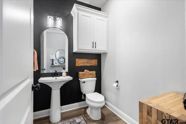 a bathroom with a toilet sink and mirror