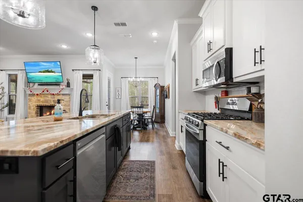 a large kitchen with stainless steel appliances granite countertop a stove and a sink