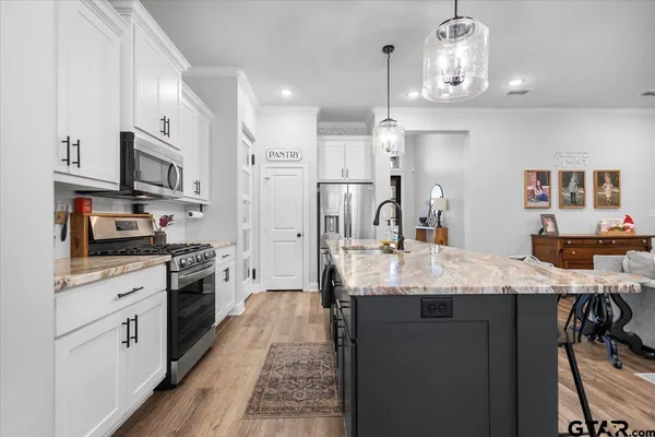 a kitchen with stainless steel appliances granite countertop a sink refrigerator stove and microwave