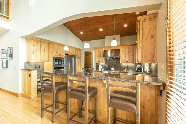 a kitchen with a table chairs refrigerator and cabinets