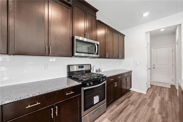 a kitchen with granite countertop stainless steel appliances and wooden cabinets