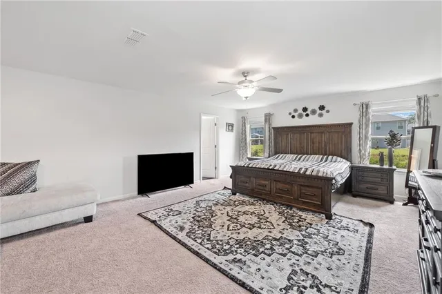 a bedroom with a bed a couch and a flat screen tv