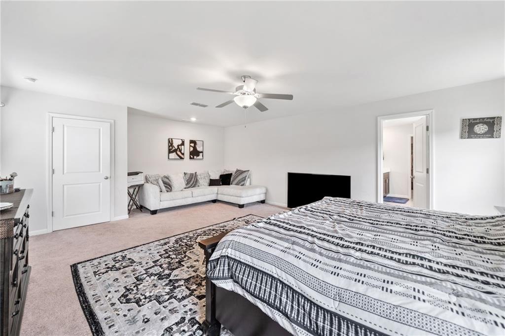 368 Murray Way Lilburn, GA 30047 - Photo 21 of 54 a bedroom with a large bed and a chandelier