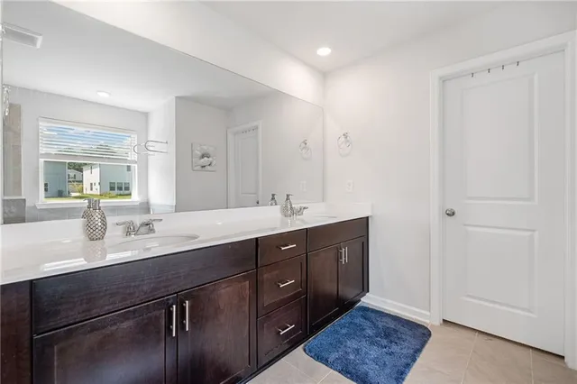 a spacious bathroom with a double vanity sink a mirror and a