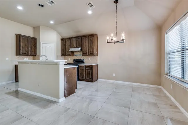 a kitchen with kitchen island a sink a counter top space appliances and cabinets